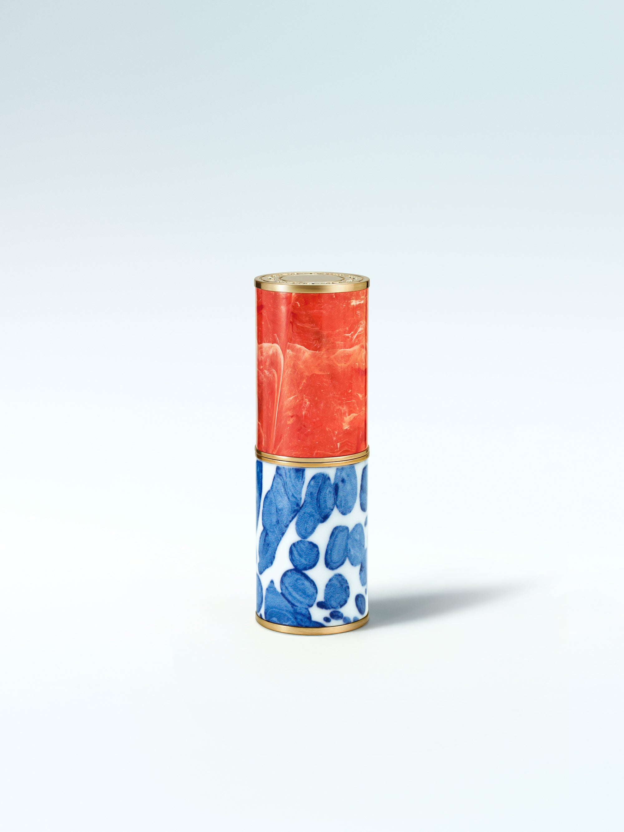 Cylindrical container with red top and blue floral pattern on a white background