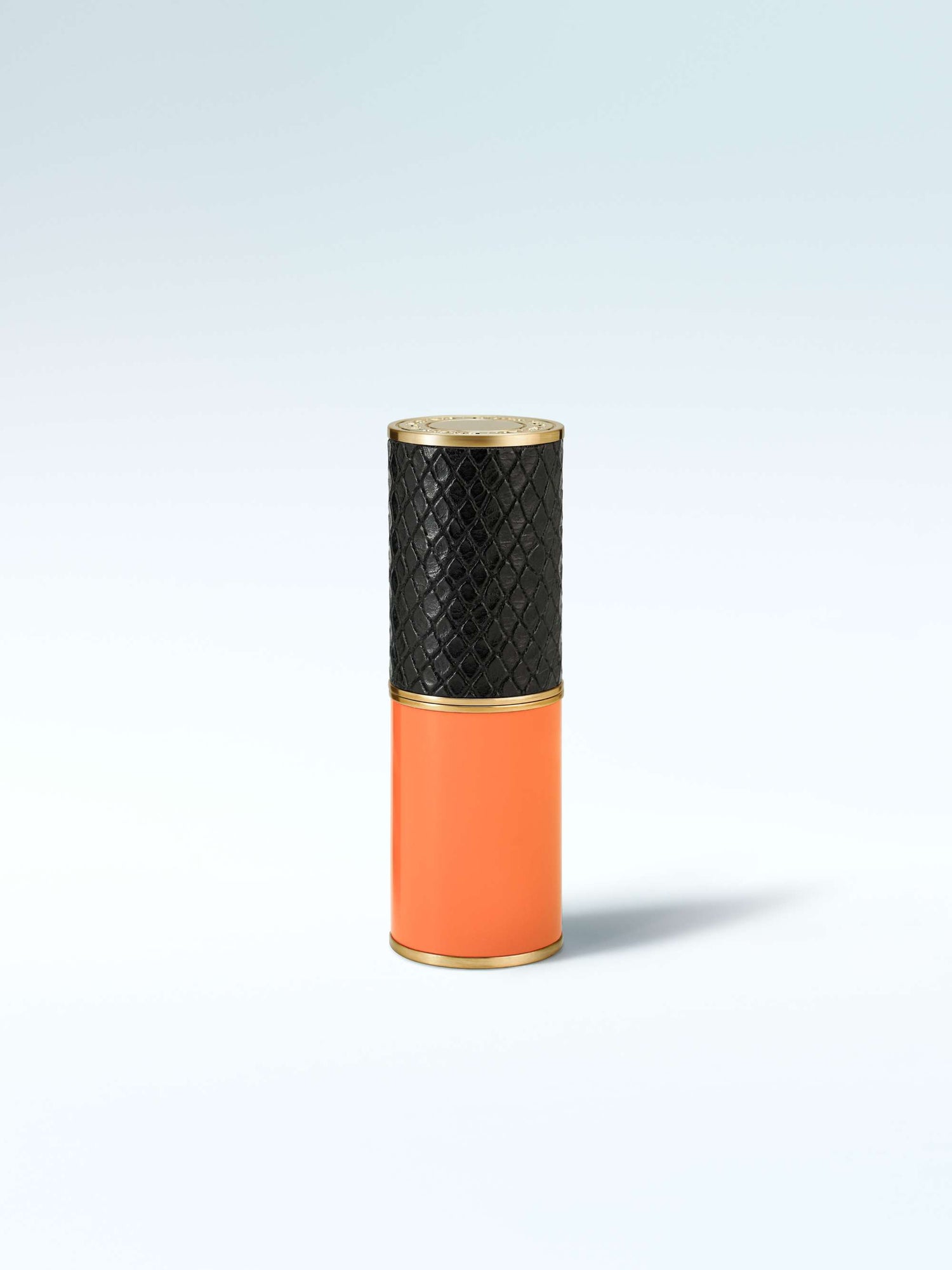 Vase with black textured top and orange bottom on a light gray background