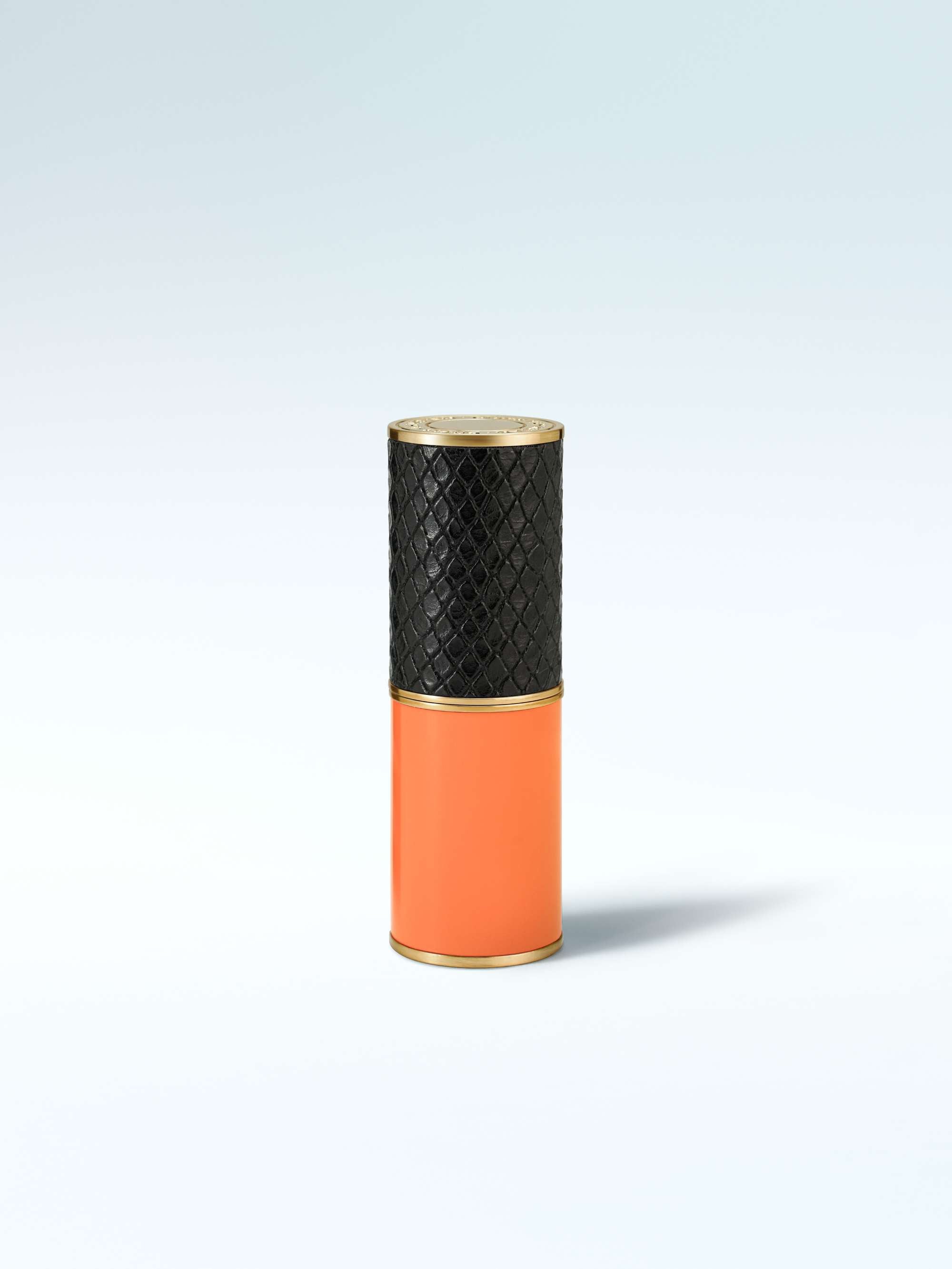 Vase with black textured top and orange bottom on a light gray background