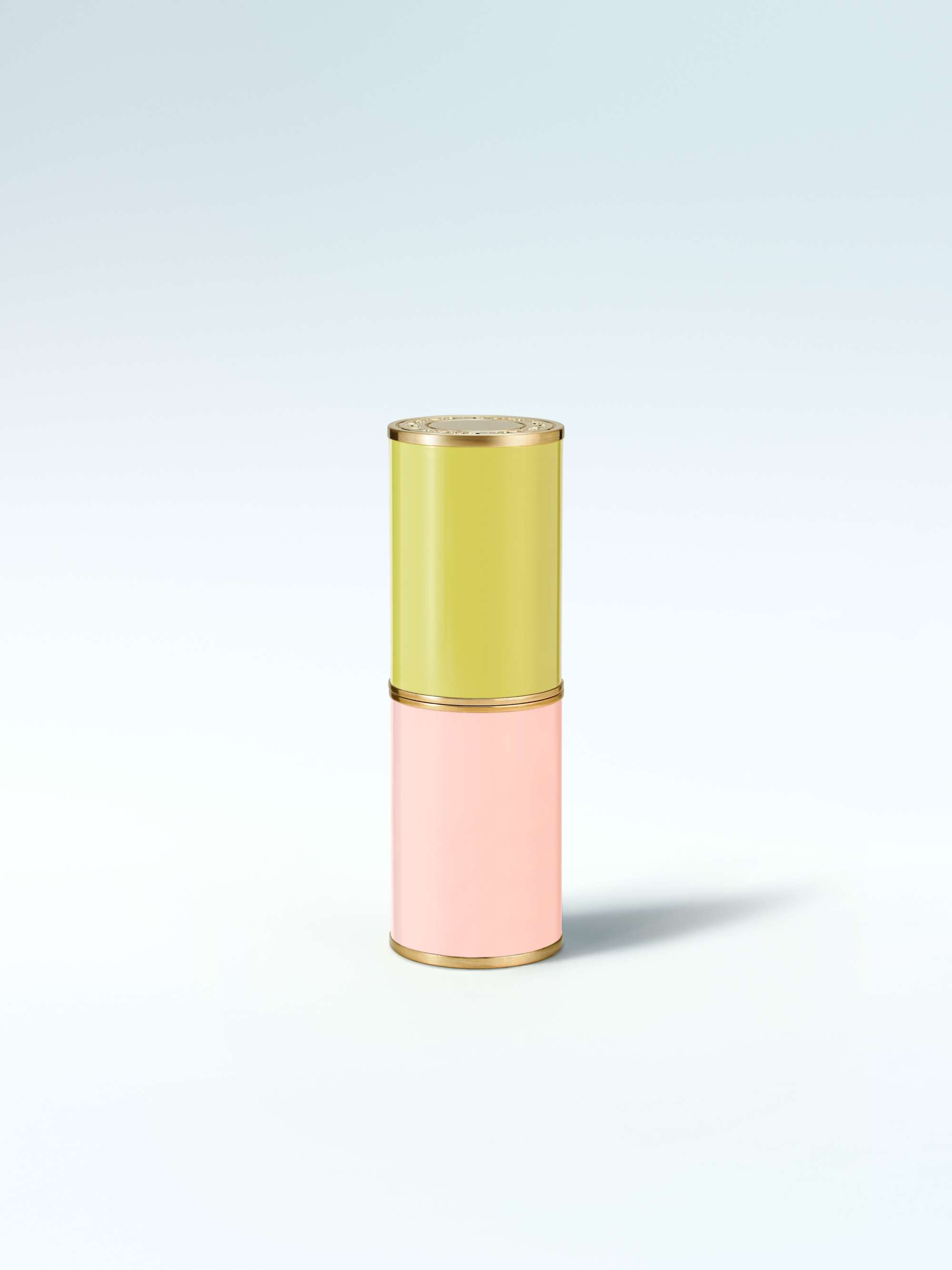 Two-toned cylindrical container with green top and pink bottom on a light gray background
