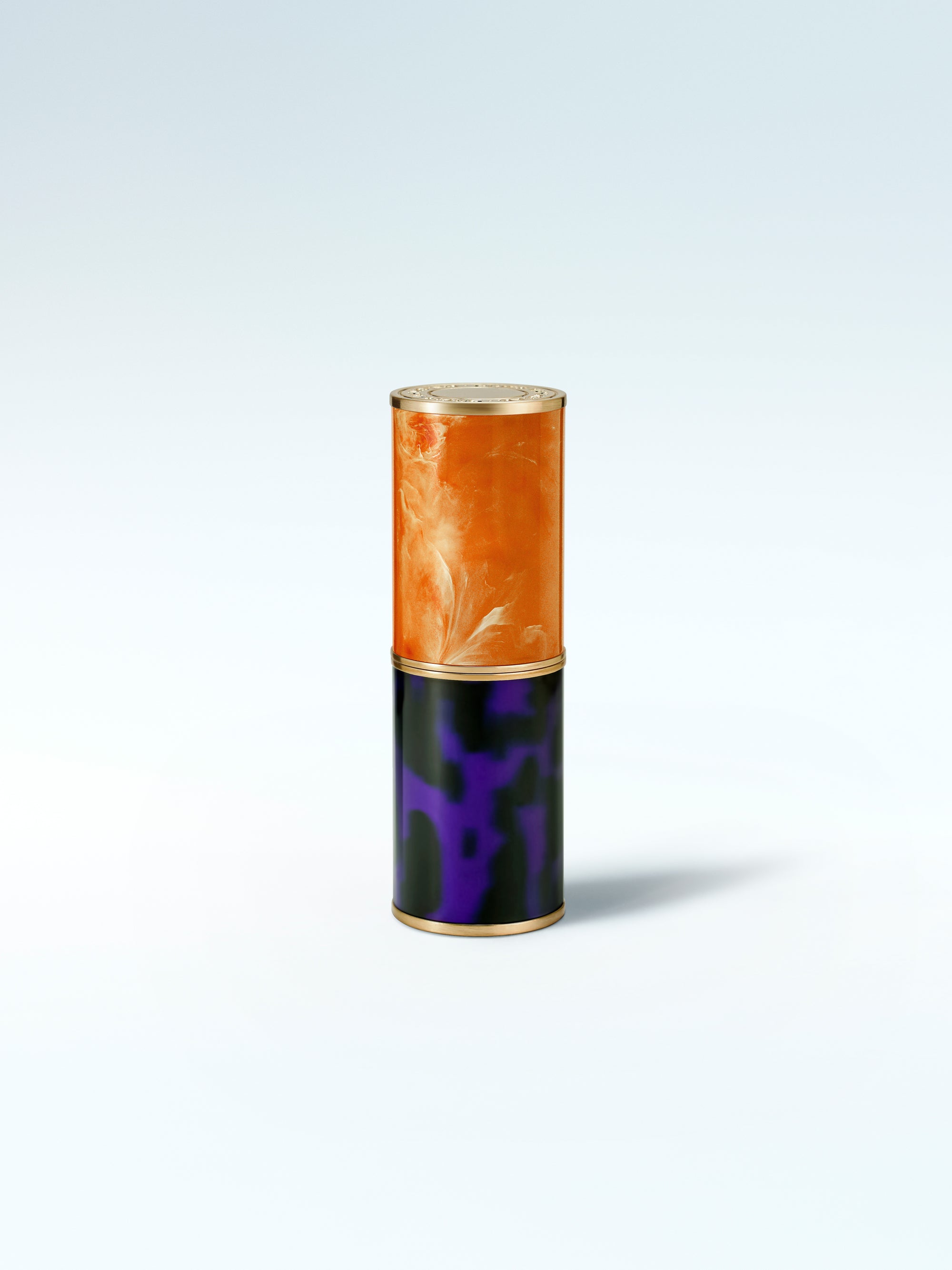 Cylindrical product with orange top and black bottom on a white background