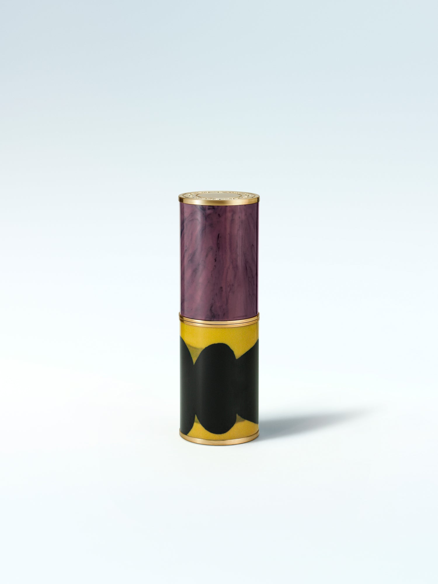 Cylindrical container with purple top and black and gold design on a white background