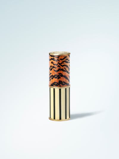 Lipstick with tiger print cap on a light blue background