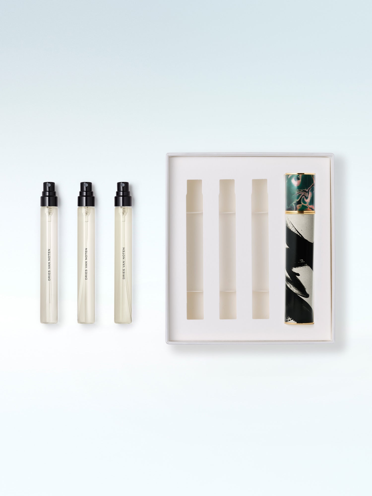 Three perfume bottles with a display case on a light blue background - Dries Van Noten