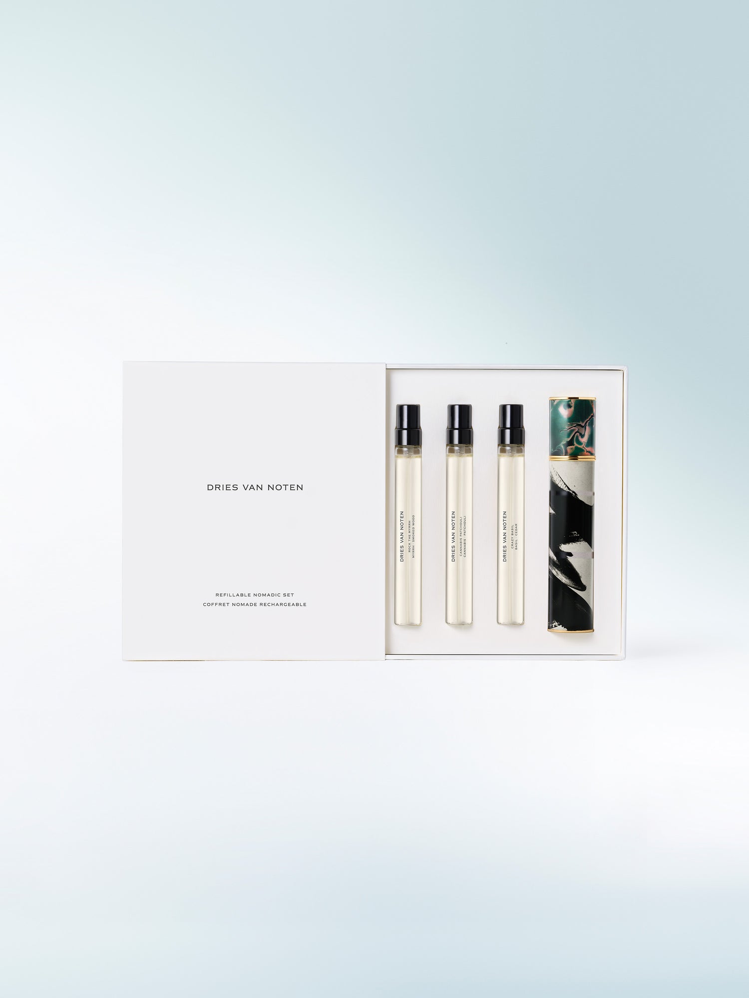 Set of three perfume bottles in a box with a light blue gradient background - Dries Van Noten
