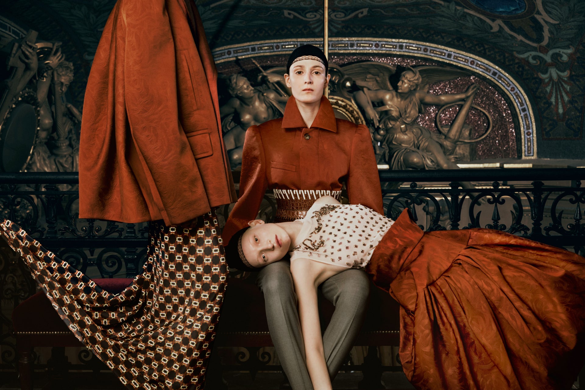 Two people in vintage-style clothing in a decorative interior setting