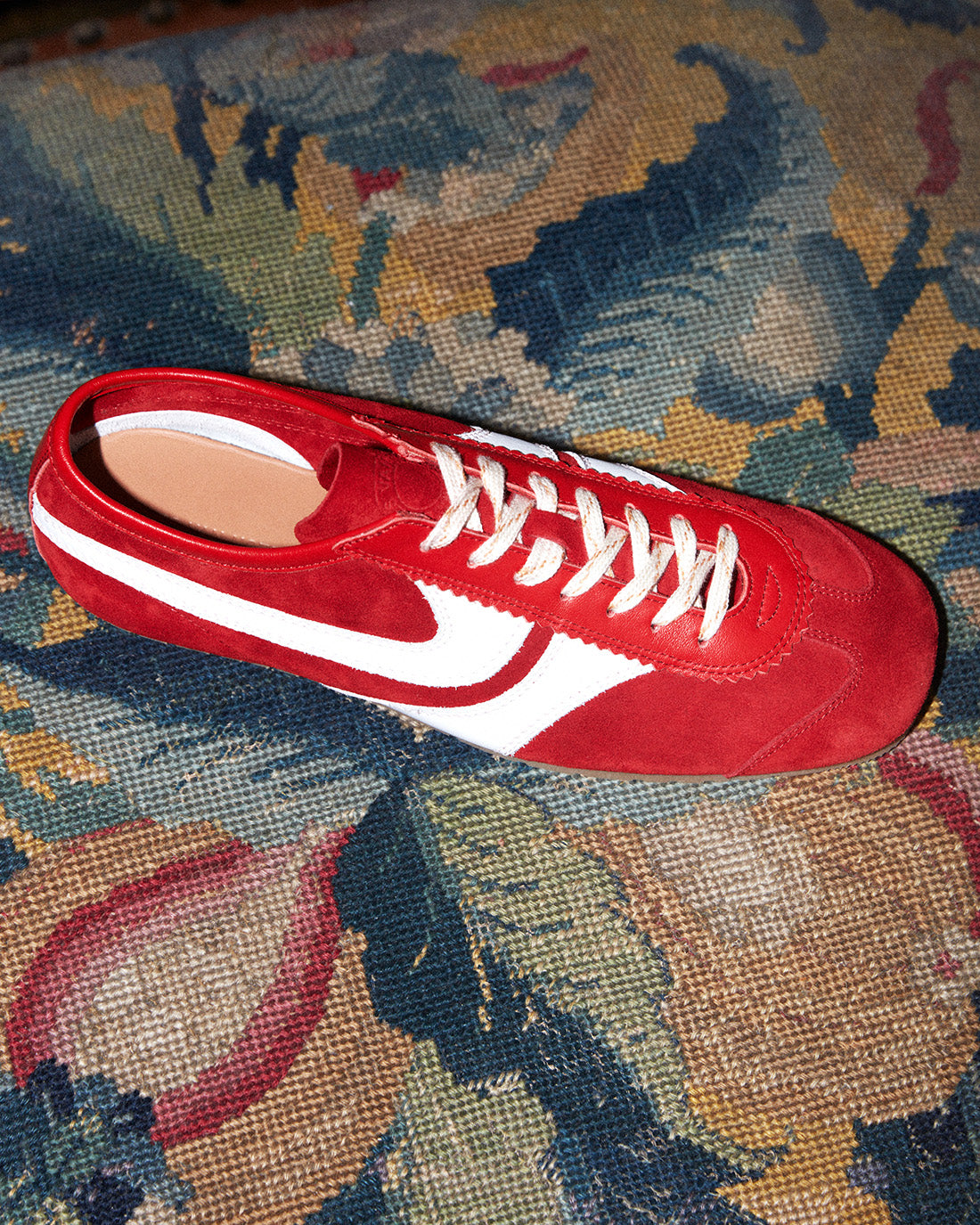 Red and white sneaker on a patterned fabric surface