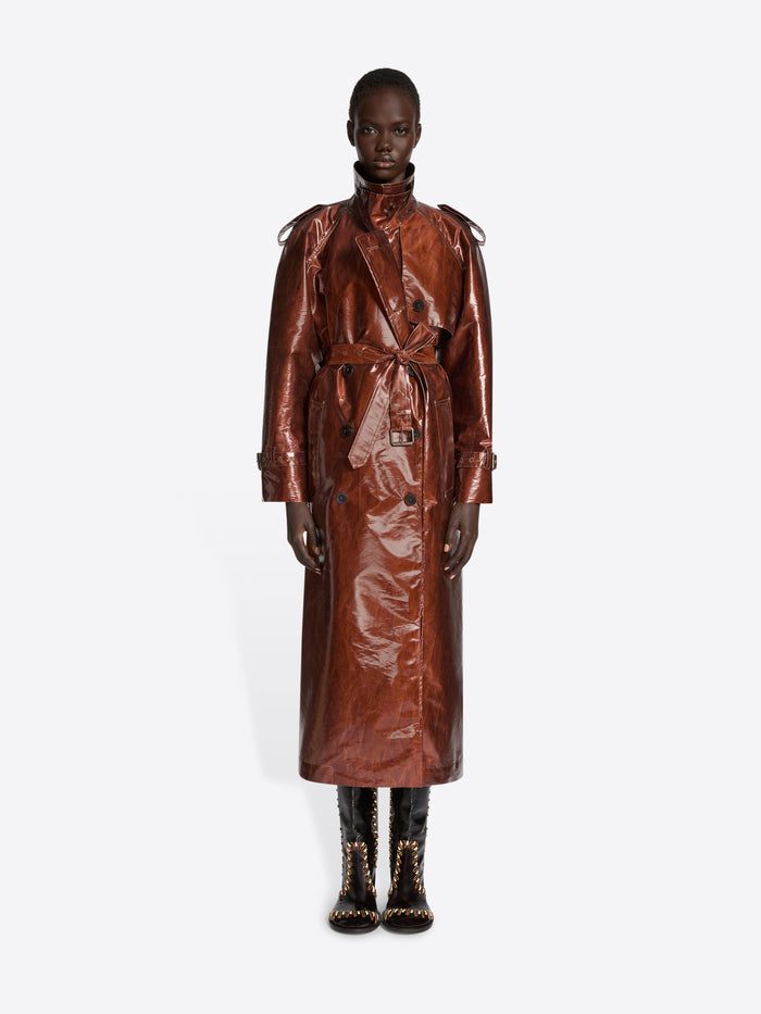 Person wearing a rust colored water repellent trench coat on a white background