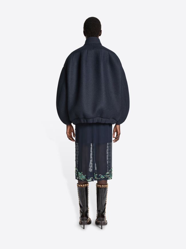 Person wearing a dark blue outfit with a matching jacket and pants on a white background