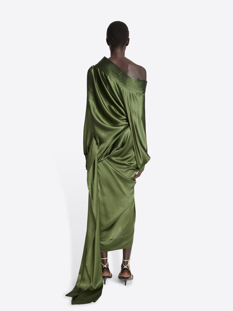 Person wearing a long, green khaki skirt and top ensemble on a white background