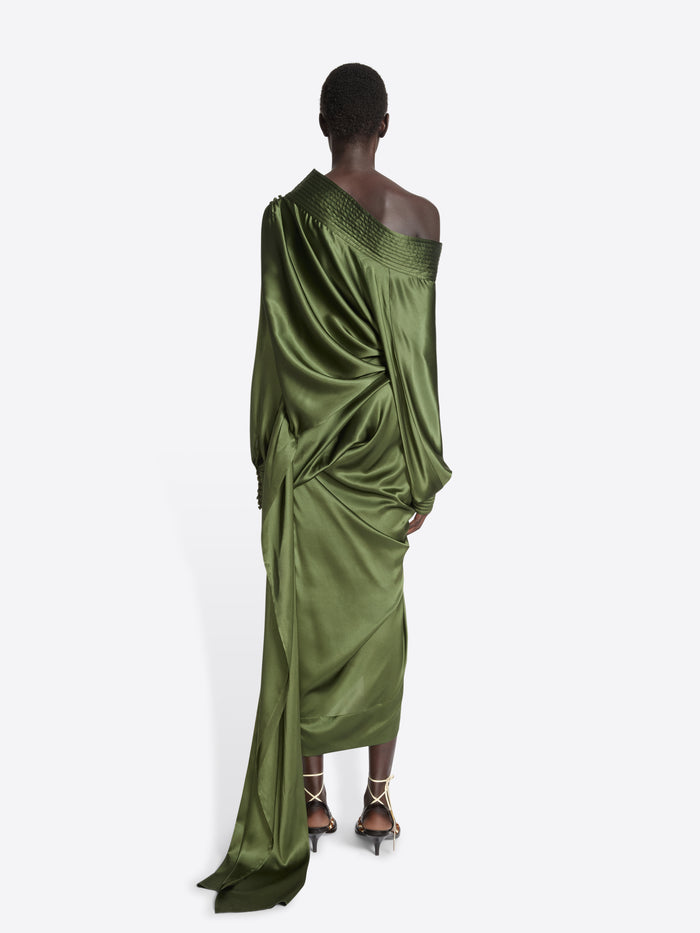 Person wearing a long, green khaki skirt and top ensemble on a white background