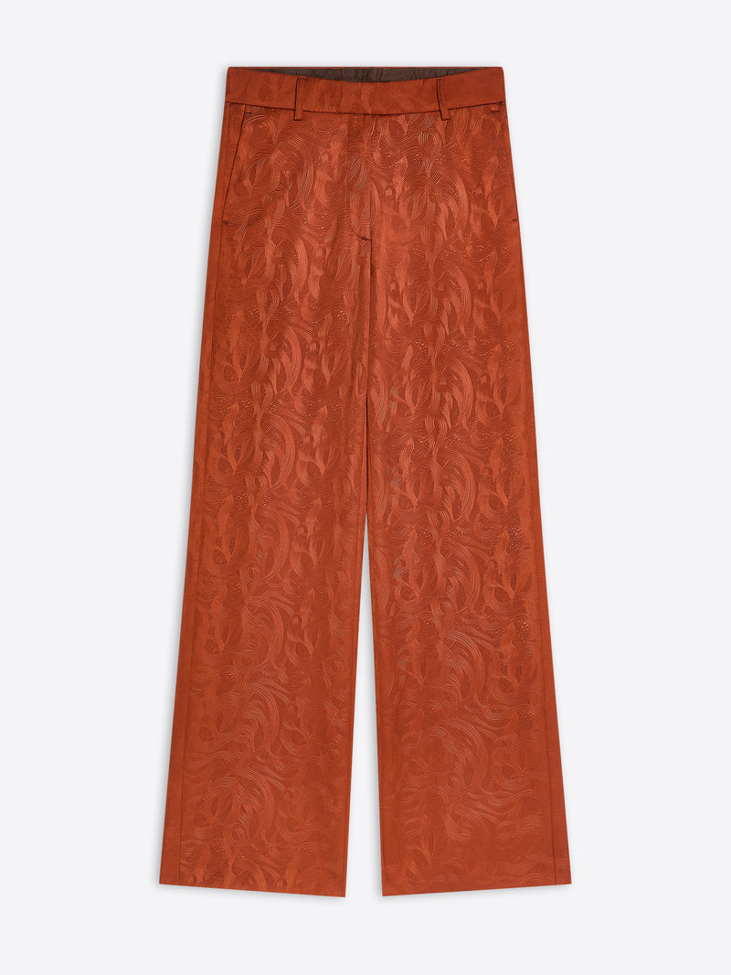 Rust coloured textured pants on a white background