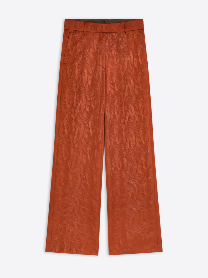Rust coloured textured pants on a white background