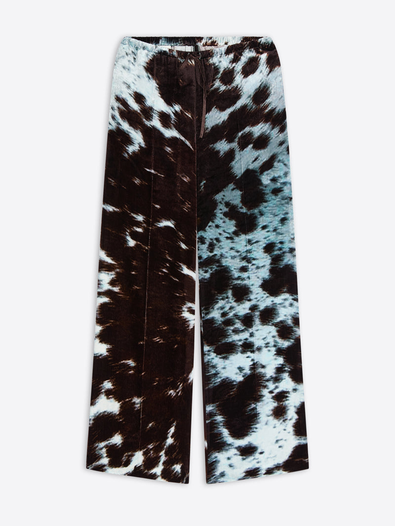 Wide-leg, elasticated pants with a black and white cowhide motif on a white background
