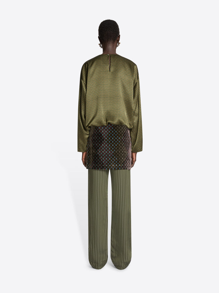 Person wearing a green patterned outfit on a white background