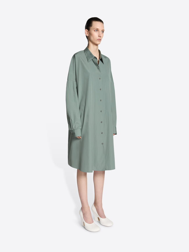Model wearing a raf colored, oversized cotton shirt dress on a white background