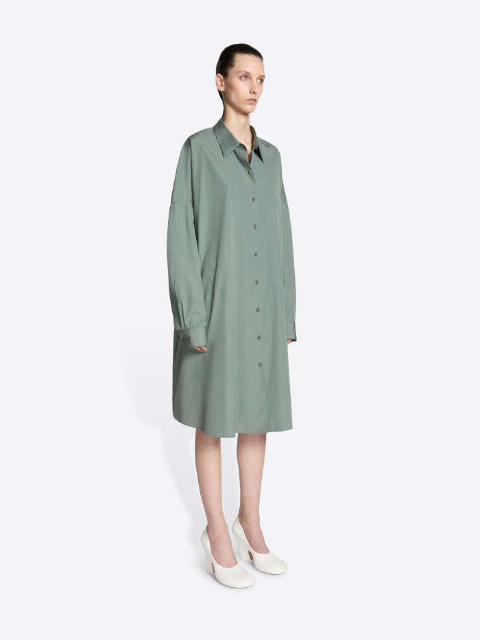 Model wearing a raf colored, oversized cotton shirt dress on a white background