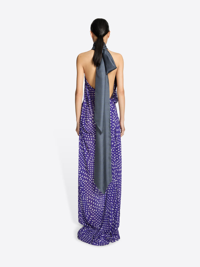 Woman wearing a long purple dress with a gray scarf on a white background