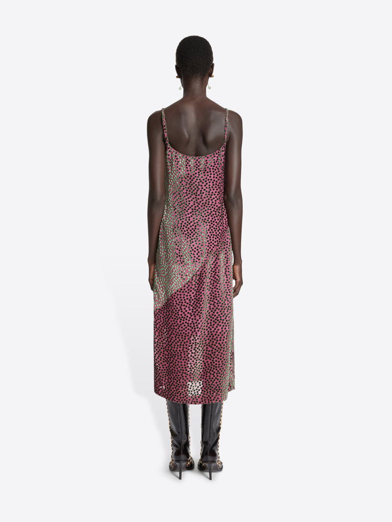 Model wearing a patterned dress with a plain background