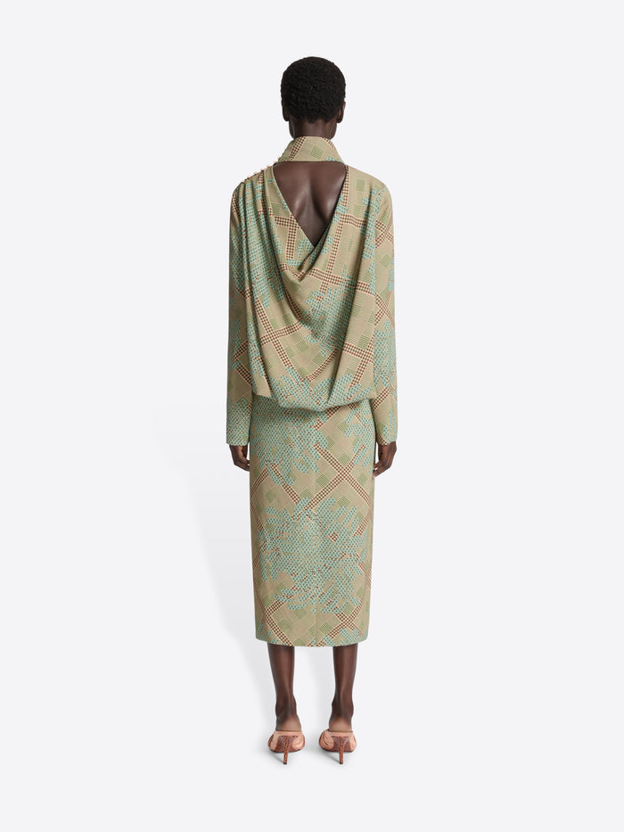 Person wearing a patterned long-sleeve dress on a white background