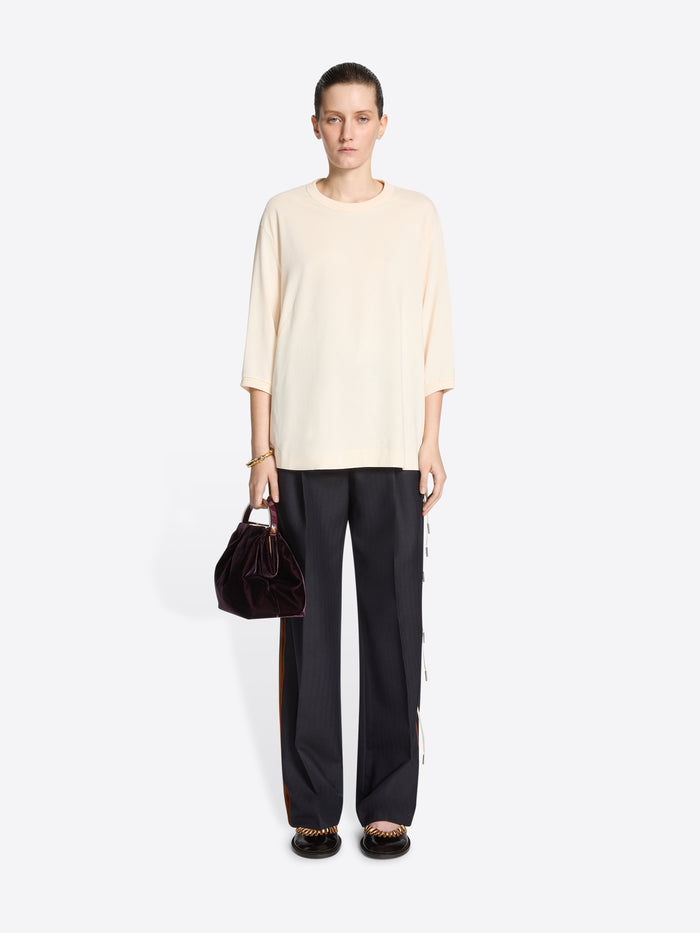 Person wearing a beige short-sleeve shirt on a light gray background