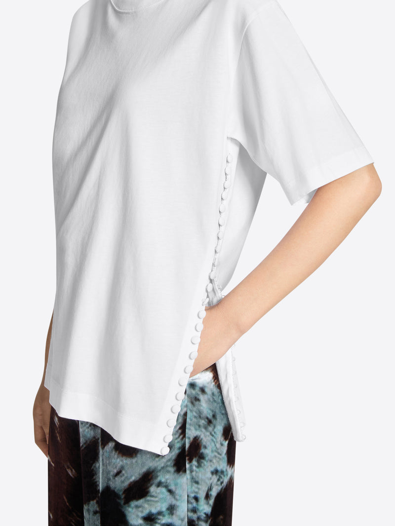 Person wearing a white t-shirt on a light gray background