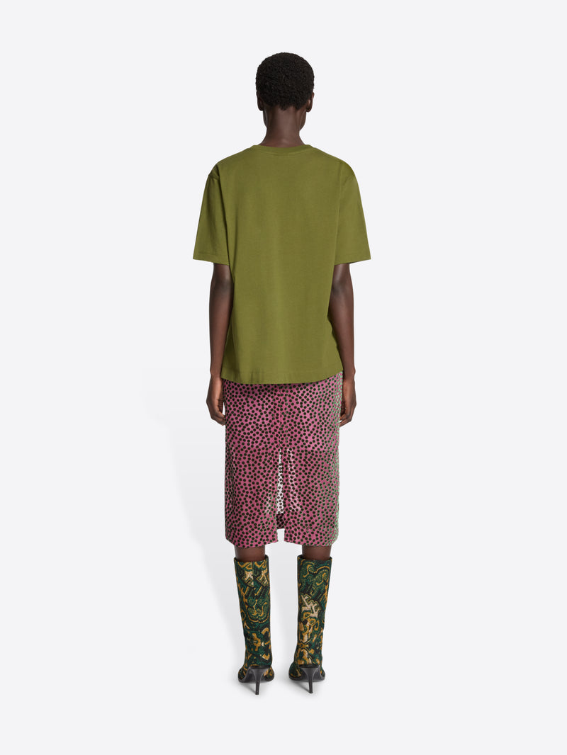 Person wearing a green t-shirt with a side slit on a white background