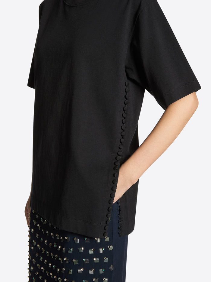 Black top with decorative trim on a white background