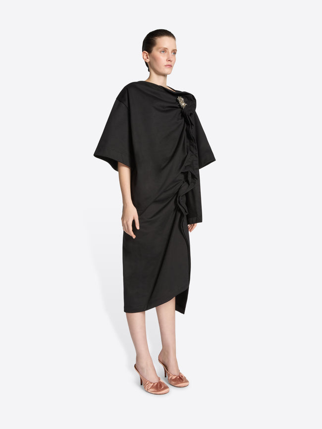 Person wearing a black skirt with a knot detail on a white background