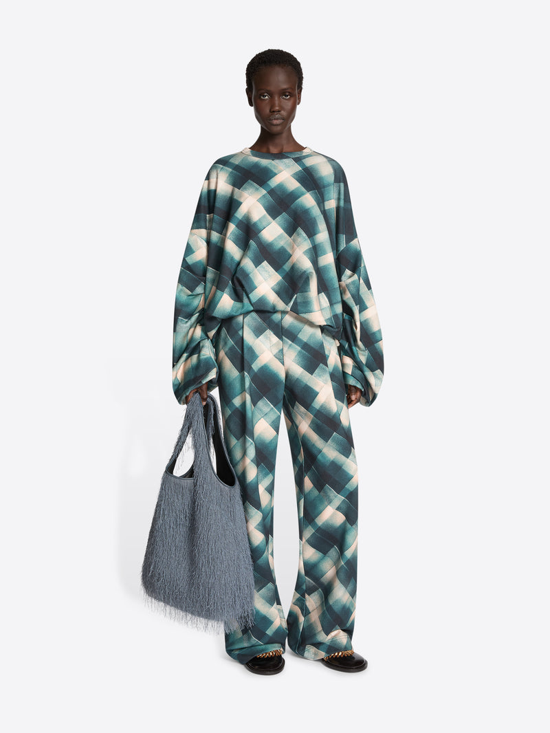 Person wearing a sweatshirt with a geometric pattern on a white background