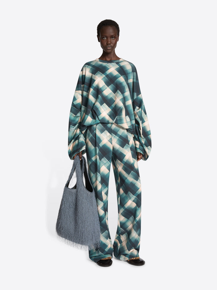 Person wearing a sweatshirt with a geometric pattern on a white background