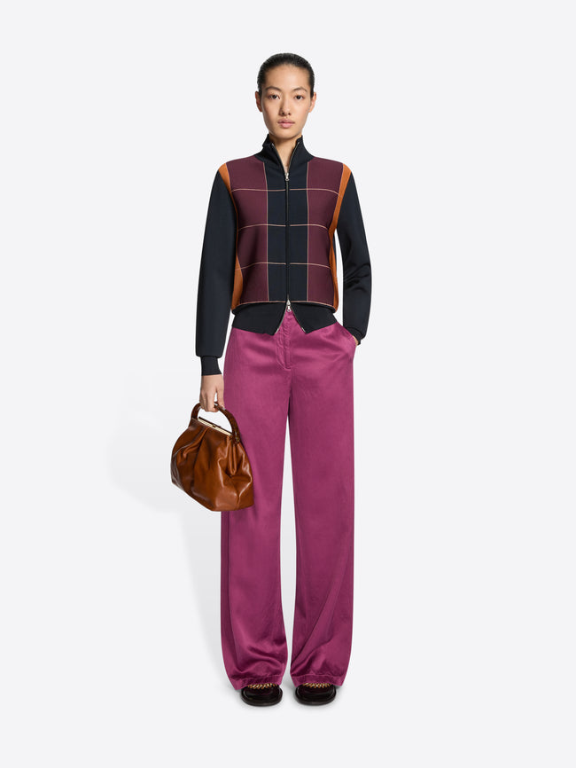 Person wearing a color-blocked jacket with a grid pattern on a white background