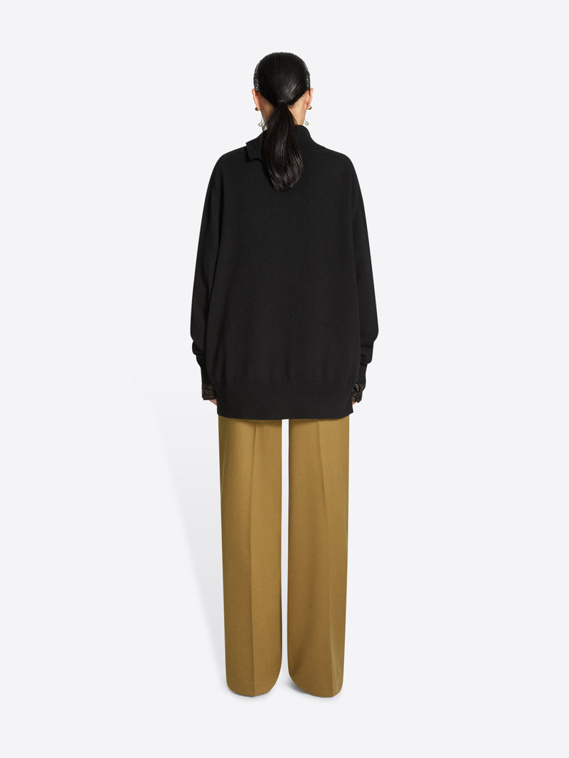 Person wearing a black turtleneck sweater on a white background