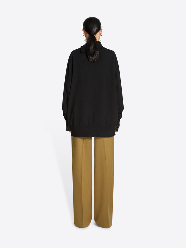 Person wearing a black turtleneck sweater on a white background