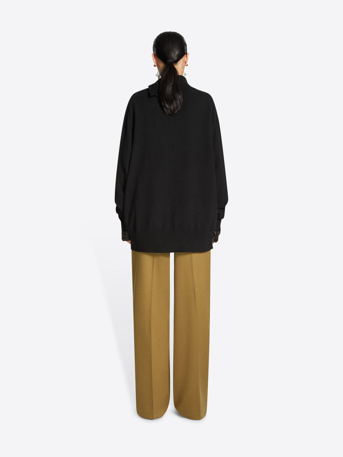 Person wearing a black turtleneck sweater on a white background