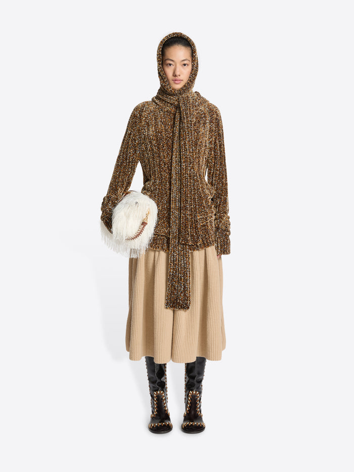 Person wearing a brown ribbed knit dress on a white background