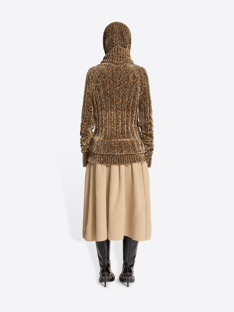 Person wearing a brown ribbed knit dress on a white background