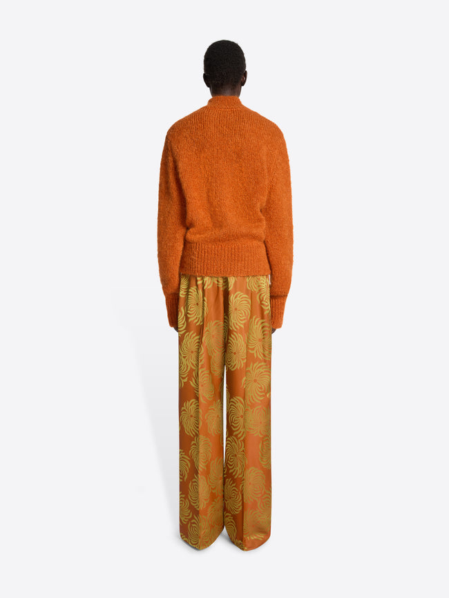 Person wearing an orange sweater on a white background