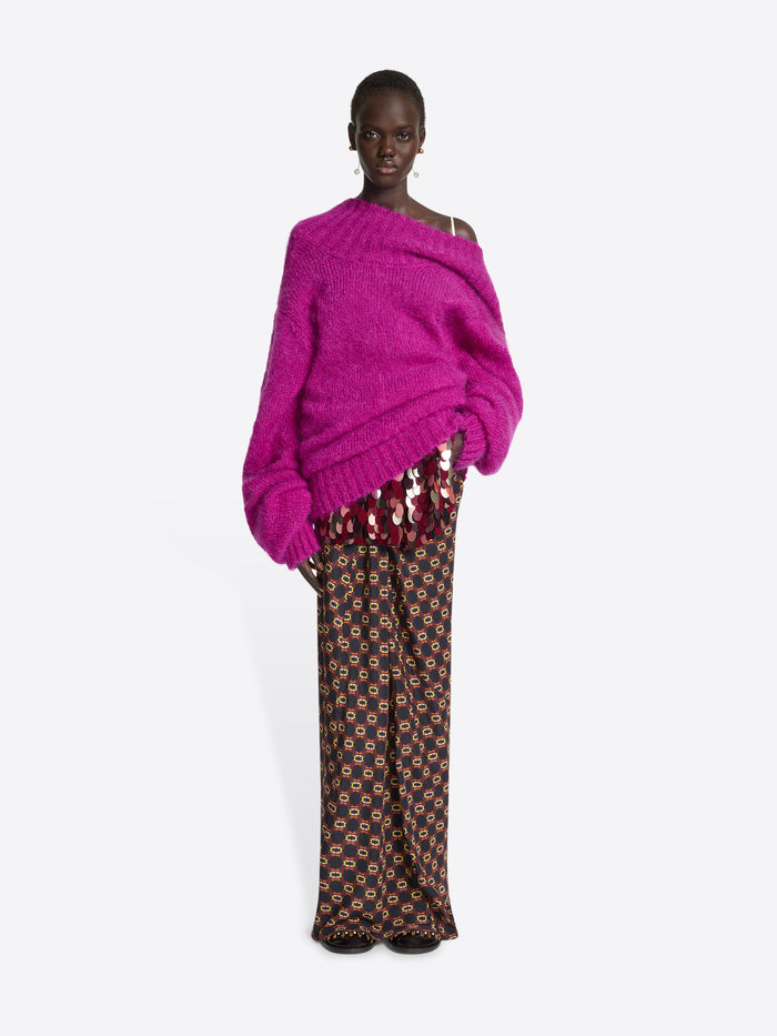 Person wearing a pink off-shoulder sweater on a white background