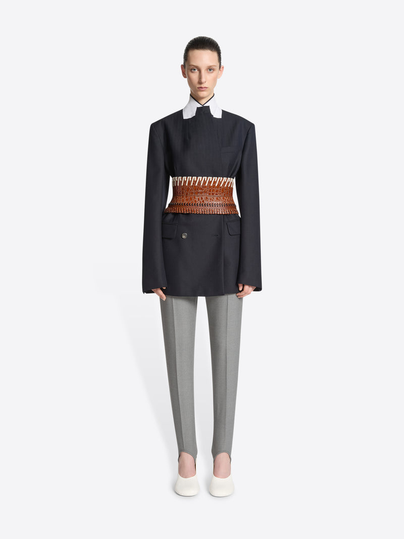 Person wearing a brown leather belt with white pattern on a white background