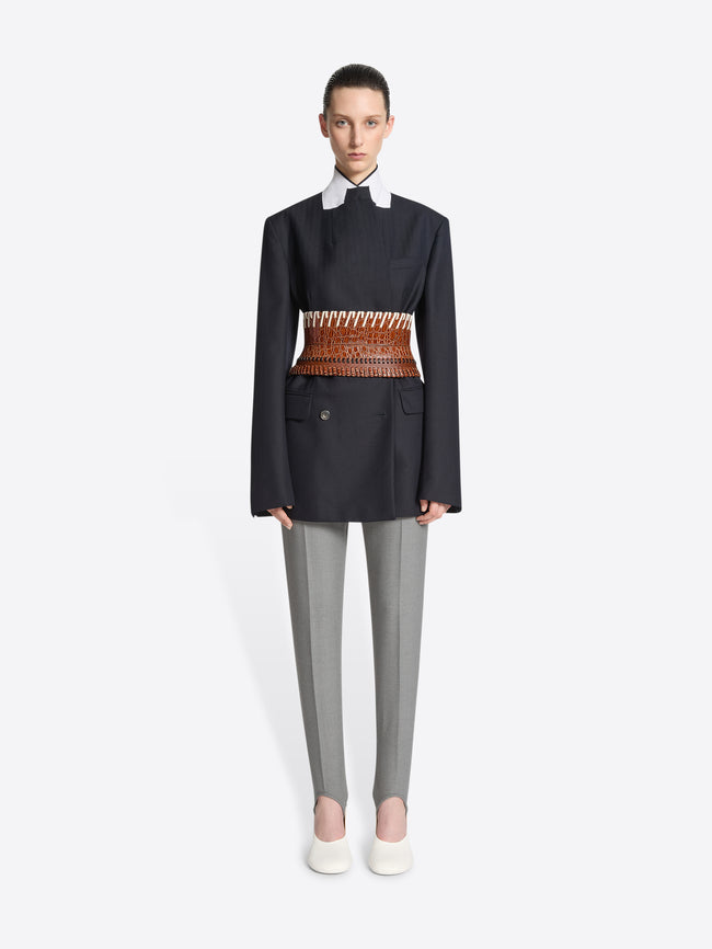 Person wearing a brown leather belt with white pattern on a white background