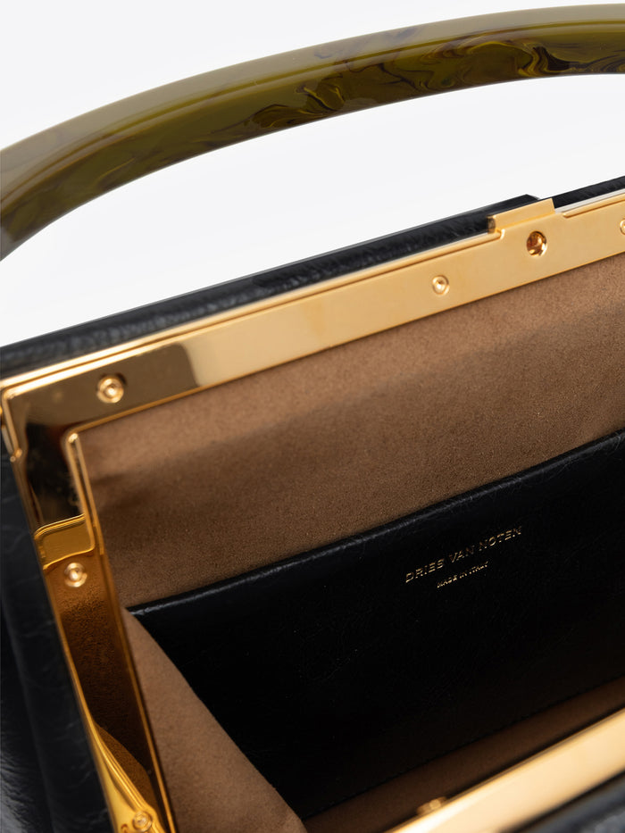 Close-up of a black pleated leather bag with gold accents and Dries Van Noten label.