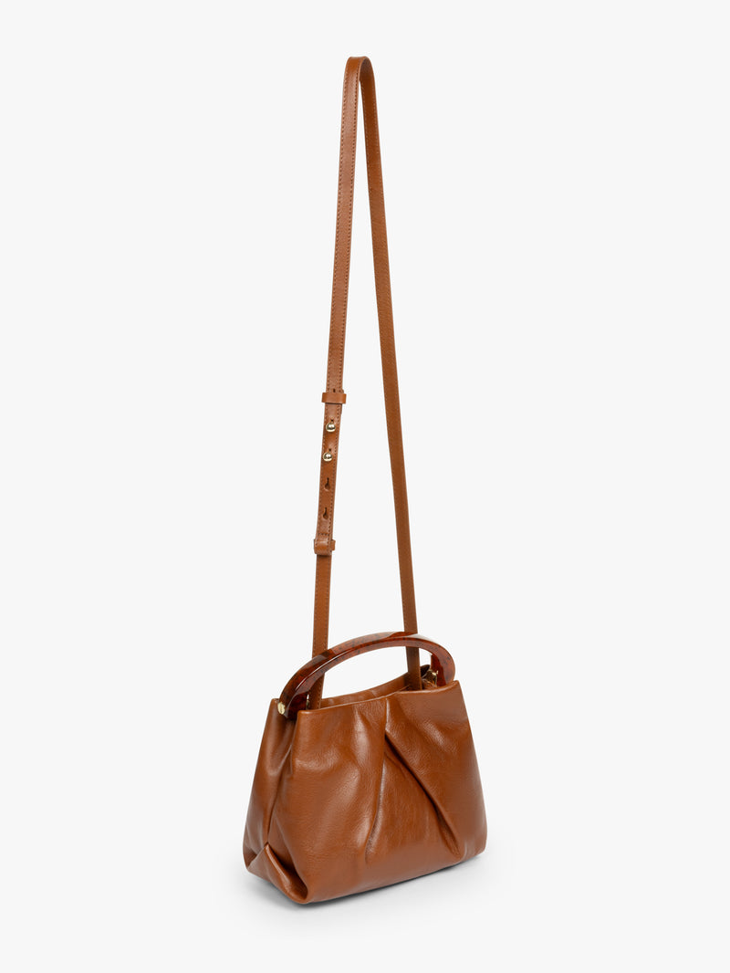 Brown leather handbag with a strap on a white background