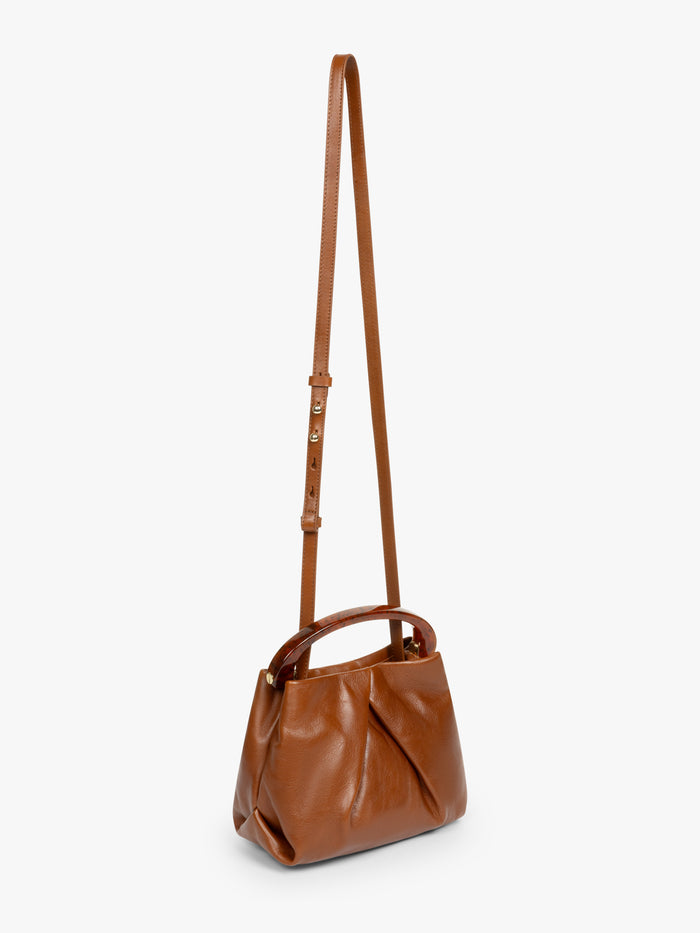 Brown leather handbag with a strap on a white background
