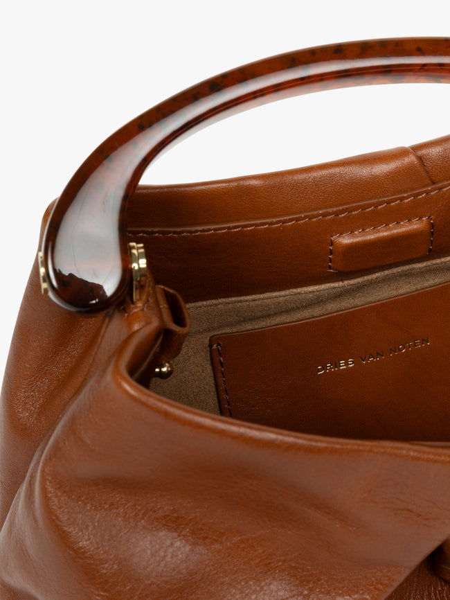 Close-up of a brown leather handbag with visible brand name.