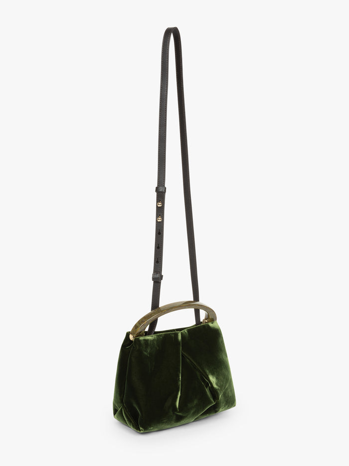 Green velvet handbag with a strap on a white background