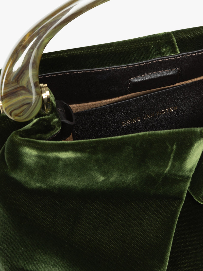 Green velvet handbag with gold handle on a white background