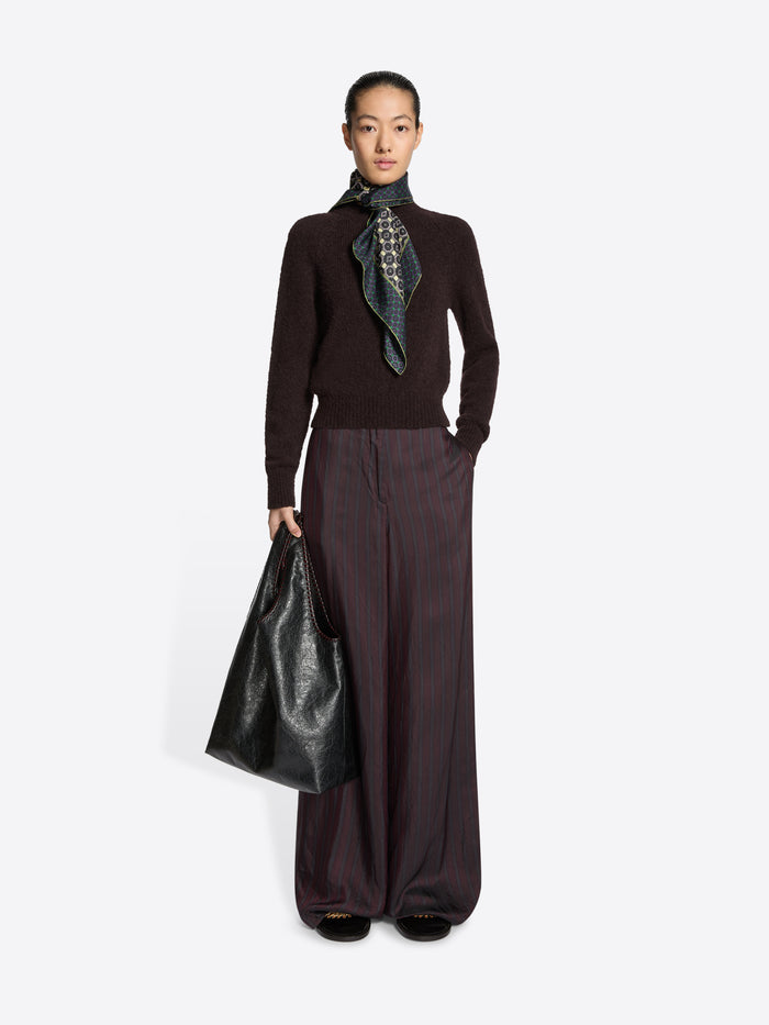 Person wearing a black leather handbag on a white background