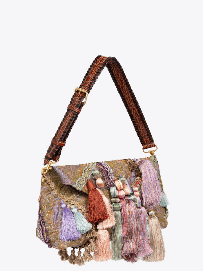 Handbag with colorful tassels and a patterned strap on a white background
