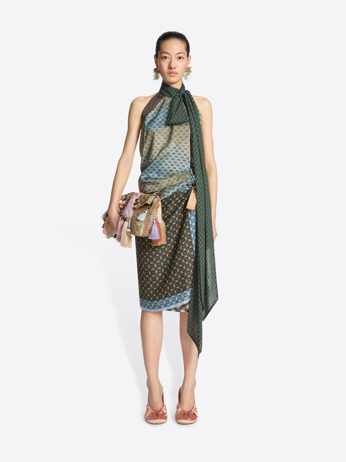 Person wearing a multicolored clutch bag with tassels on a white background